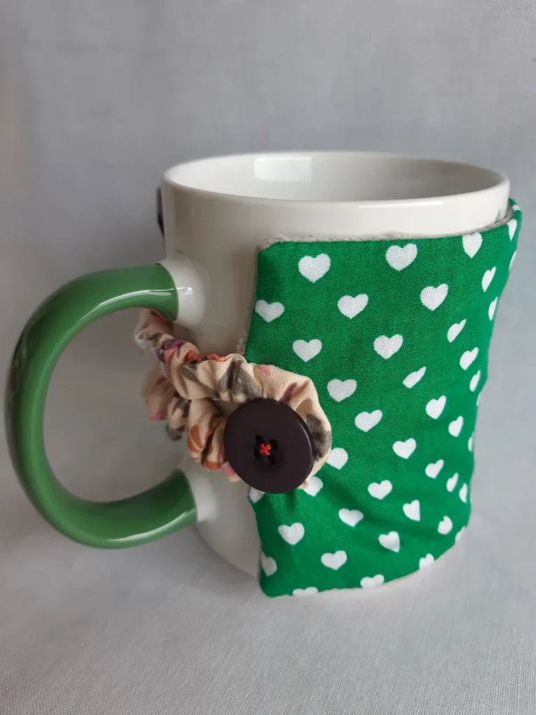 housse de tasse en coton motif coeur vert avec elastique et gros bouton pour faire un cadeau artisanal de Normandie original et utile