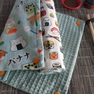 Mignon rouleau d'essuie-tout lavable fait main au Havre aux motifs japonais kawaii avec sushis, onigiris, maki, wasabi et dorayakis, face nid d'abeille absorbante bleu clair et boutons pressions oranges Cousu Mel