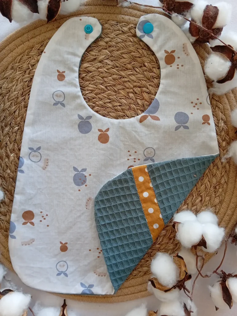 bavoir réversible imperméable et absorbant en coton enduit et éponge nid d'abeille. Motif pomme et pois