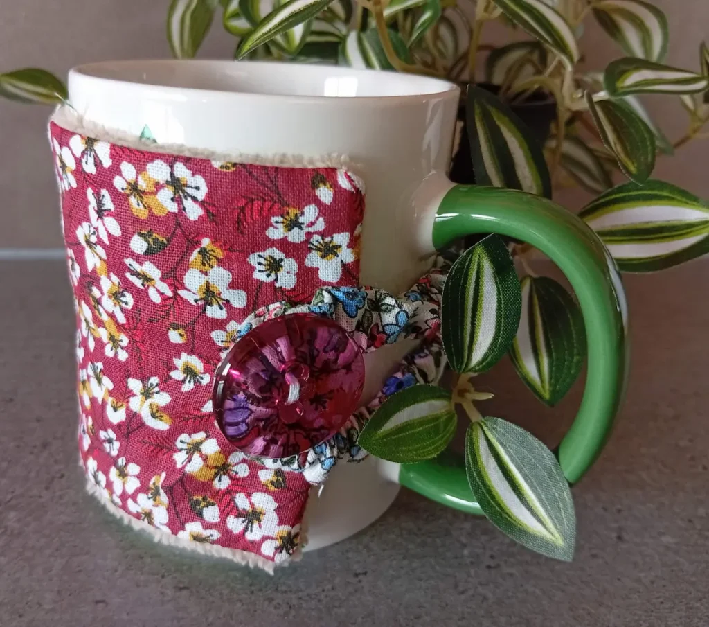 housse de tasse avec petites fleurs sur fond bordeaux et bouton tranparent fuschia, doublure en bambou taupe