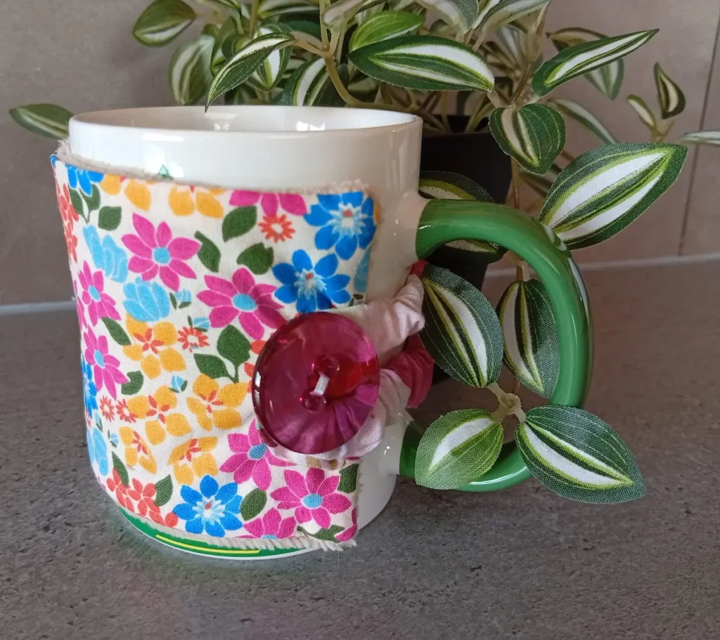 housse de tasse avec petites fleurs rose jaune bleu sur fond blanc et bouton tranparent fuschia, doublure en bambou taupe