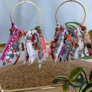 Boucles d'oreilles plumes boheme chic en tissus roses et perles bois - Cousu Mel, accrochées sur un support doré et fonc blanc et paille tressée
