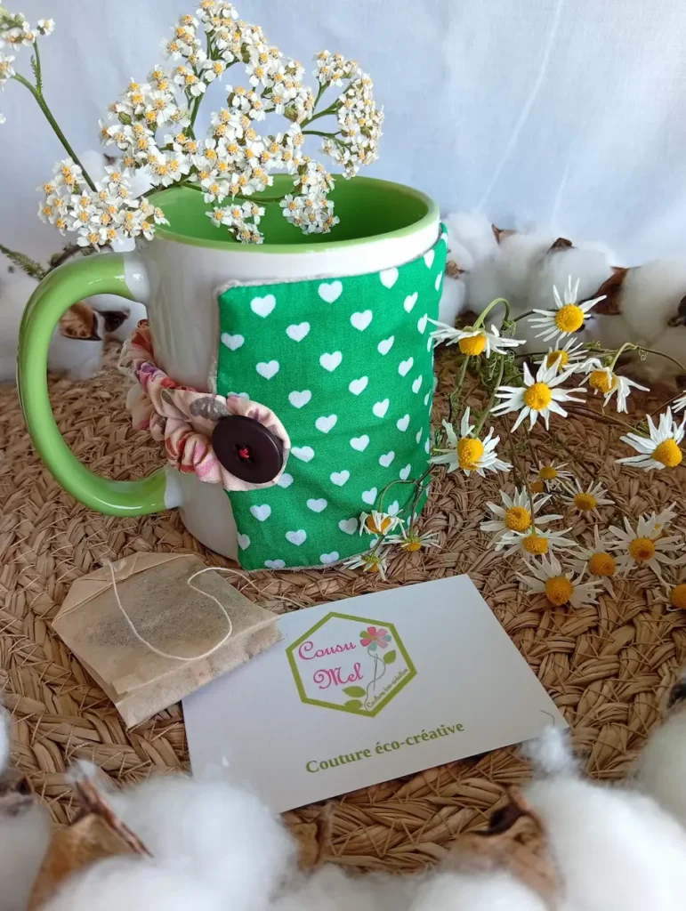 Housse de mug artisanale en tissu vert à cœurs blancs incluse dans le coffret pause détente.