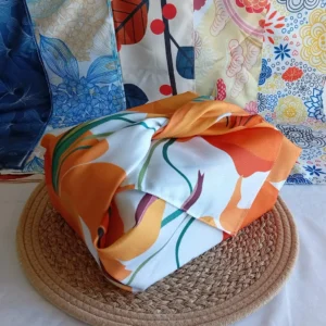 Furoshiki emballage cadeau japonais motif Lys, embllé autour d'une boîte. En fond : 5 motifs différents de furoshiki