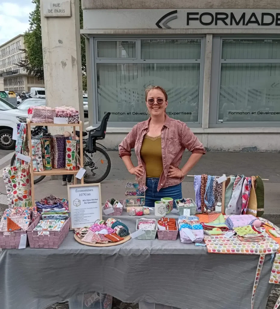 créatrice de Cousu Mel derrière son stand coloré à un marché de créateur au Havre, rue de Paris