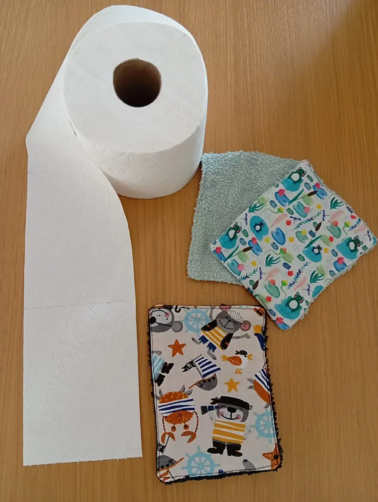 exemple d'accessoire zero dechet fait main : 3 serviettes en éponge bleu clair et noir et coton imprimé grenouilles et animaux pirates au format d'une feuille de papier toilette